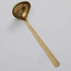 a golden spoon on a white surface