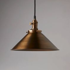 an antique brass pendant light hanging from a ceiling