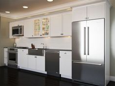 a kitchen with all white cabinets and stainless steel appliance, including refrigerators