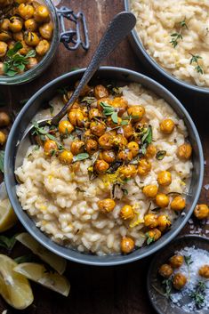 two bowls filled with rice and chickpeas next to lemon wedges on a wooden table