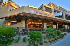 an outside view of a restaurant with palm trees