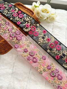 three different types of decorative ribbons on a white blanket next to a basket with flowers