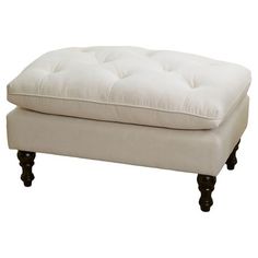 a white foot stool with buttons on the top and legs, in front of a white background