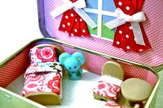 a pink suitcase with red and white polka dots on it, filled with little toys