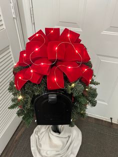 a mailbox decorated with red bows and lights