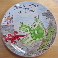 a plate with an image of a green dragon and castle on it that says, once upon at time