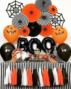 a table topped with halloween decorations and balloons