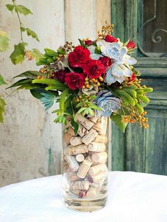 a vase filled with flowers and rocks on top of a table