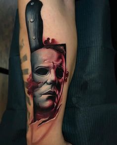 a person with a knife and skull on their arm