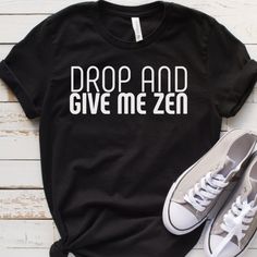 Drop and Give Me Zen: Funny yoga or workout shirt to keep you or your workout buddies laughing through any workout. Great gift for your yoga partner or personal trainer.  You've now found the staple t-shirt of your wardrobe.  This unisex shirt is made of 100% ring-spun cotton and is soft and comfy. The double stitching on the neckline and sleeves add more durability to what is sure to be a favorite!   * 100% ring-spun cotton * Sport Grey is 90% ring-spun cotton, 10% polyester * Dark Heather is 6 Sporty Yoga T-shirt With Letter Print, Black Gym Tops With Funny Text, Black Gym Top With Funny Text, Athletic Fit Yoga T-shirt With Crew Neck, Athletic Fit Crew Neck T-shirt For Yoga, Sporty Workout T-shirt With Funny Text, Black Letter Print Top For Yoga, Sporty Gym T-shirt With Funny Text, Sporty Letter Print T-shirt For Yoga