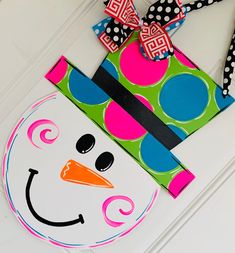 a snowman door hanger with polka dots and a bow on it's head