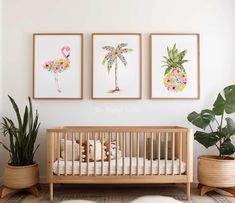 three paintings hang on the wall above a crib