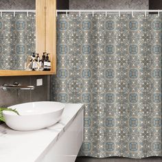 a bathroom with a sink, mirror and shower curtain that has an intricate design on it