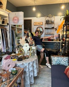 a woman is sitting on a table in a clothing store