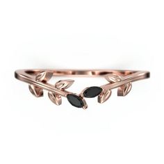 a rose gold ring with leaves and black stones on the side, set against a white background