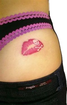 a woman's stomach with a tattoo on her belly and pink lipstick in the shape of a heart