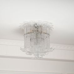 a chandelier hanging from the ceiling in a room with white walls and trim