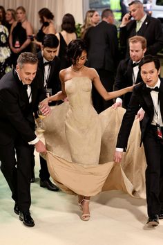 two men and a woman in formal wear are dancing with each other at an event