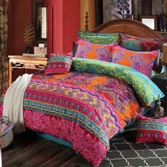 the bed is made with colorful comforters and pillows