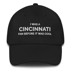 "You are buying a beautiful Cincinnati Football Dad Cap hat with the Cincinnati Football design embroidered onto it, making the perfect gift for anyone that loves Cincinnati Football! Dad hats aren't just for dads. This one's got a low profile with an adjustable strap and curved visor. * 100% chino cotton twill * Green Camo color is 35% chino cotton twill, 65% polyester * Unstructured, 6-panel, low-profile * 6 embroidered eyelets * 3 ⅛\" (7.6 cm) crown * Adjustable strap with antique buckle * Blank product sourced from Vietnam or Bangladesh" Curved Bill Hats With Letter Print For Fans, Letter Print Baseball Cap For Fan Gear, Letter Print Baseball Cap For Fans, Sports Fan Hats With Letter Print And Curved Brim, Fan Gear Hat With Embroidered Logo, One Size Fan Gear Hat With Embroidered Logo, Cotton Fan Merchandise Cap, Cotton Cap For Fan Merchandise, Sports Fan Cotton Hat For Fan Merchandise