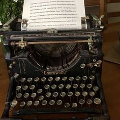 an old fashioned typewriter sitting on top of a wooden table