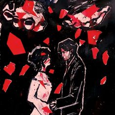 a man and woman standing next to each other in front of red squares on black paper