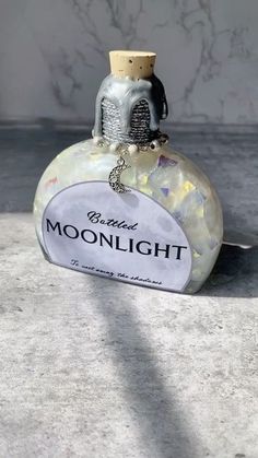 an empty bottle sitting on the ground next to a marble wall with writing on it