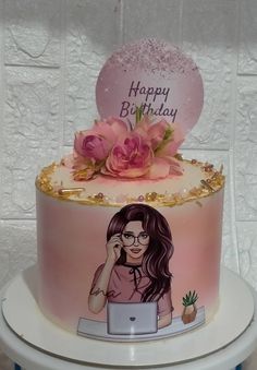 a birthday cake decorated with an image of a woman on her laptop and pink flowers