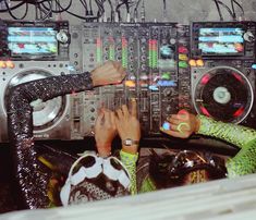 two people with their hands on the controls of a dj's equipment set up