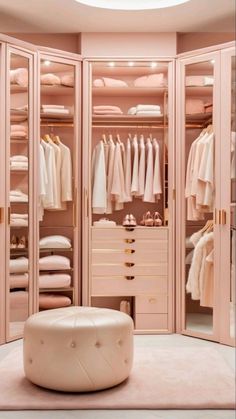 a walk in closet with lots of clothes on hangers and white leather stools