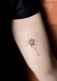 a small dog paw tattoo on the left inner arm and leg, with stars coming out of it