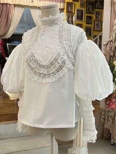 This price includes a blouse only. Dress / Top Details:Lace TrimNeckline:High Neck / Ruffle NecklineSleeves:Leg-of-Mutton Sleeves  	 		 			Size 			XS 			S 			M 			L 			XL 		 		 			Bust 			82 			86 			90 			94 			98 		 		 			Waist 			64 			68 			72 			76 			80 		 		 			Sleeve Length 			58 			58 			60 			60 			62 		 		 			Full Length 			58 			58 			60 			60 			62 Fitted Vintage Padded Blouse, Fitted Cotton Tops With Bishop Sleeves, Fitted Cotton Top With Bishop Sleeves, Fitted Bishop Sleeve Tops With Ruffles, Vintage Lantern Sleeve Tops For Fall, Vintage Lantern Sleeve Tops For Spring, Vintage White Bishop Sleeve Tops, Fitted Cotton Blouse With Bishop Sleeves, Cotton Bishop Sleeve Fitted Blouse