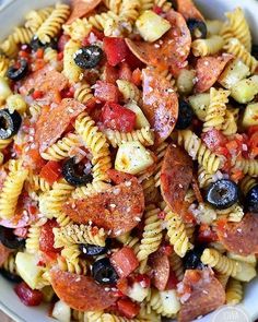 a bowl filled with pasta salad on top of a wooden table