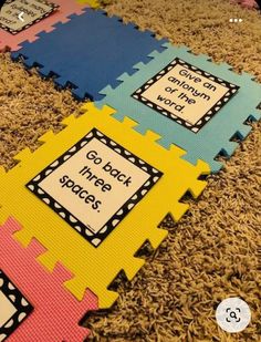 colorful foam mats with words on them sitting on the floor in front of a carpet