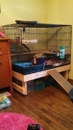 an image of a dog in a cage that is on top of a wooden floor