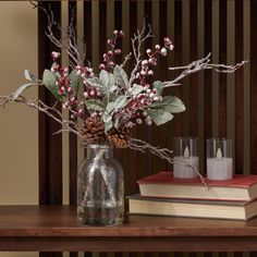 a vase filled with flowers sitting on top of a wooden table next to two candles