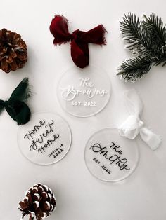 three personalized glass ornaments with pine cones on the top and one for each ornament