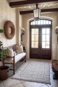 a foyer with a bench, potted plants and a large rug on the floor