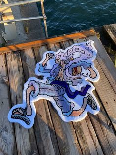 an image of a sticker on the ground next to some water and a dock