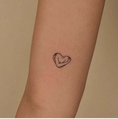 a small heart tattoo on the arm