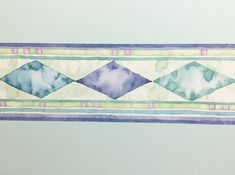 a watercolor painting of blue, green and purple diamonds on a white paper background