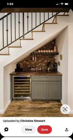 a kitchen with stairs leading up to the upper floor and below it is a wine cellar