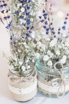 two mason jars filled with blue and white flowers