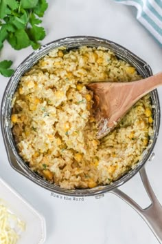 a pot filled with rice and vegetables next to some parsley on the counter top