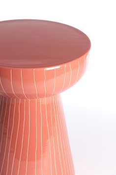 an orange table with lines on it and a round top that is made out of clay