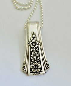 a silver necklace with flowers on it