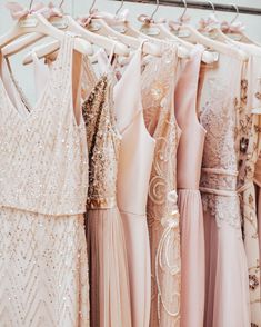 there are many different dresses hanging on the rack in front of each other and one is pink