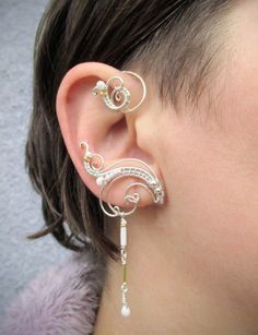 "Average delivery terms USA, France, Ireland - 3-4 weeks Australia, Canada - 4-6 weeks Netherlands, Spain - 2-3 weeks A pair of ear cuffs made of silver plated copper wire, white and golden glass beads with delicate danglings. The length of the dangles is 1 1/3\" (3.4 cm).  These earrings are covered with metal protecting lacquer. No piercing needed, they are worn behind the ear.  Another metal (copper, brass) or beads or length of the dangles are also possible if you prefer to make some changes Unique Adjustable Pierced Ear Climbers, Pierced Metal Ear Cuff With Unique Style, Pierced Metal Ear Cuff As A Gift, Adjustable Unique Style Ear Climbers, Silver Metal Ear Climbers As Gift, Unique Silver Metal Ear Cuff, Silver Ear Cuff For Gift, Silver Ear Cuff For Pierced Ears Gift, Metal Ear Cuff For Pierced Ears As Gift