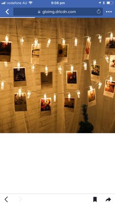 the wall is decorated with pictures and candles for christmas lights are strung from strings above them