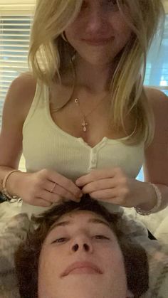 a woman is cutting another mans hair in bed